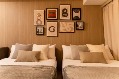 two beds in a room with pictures on the wall at Dogenzaka Hotel 306 in Tokyo
