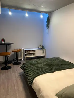 a bedroom with a bed and a table and stool at west16 in Tokyo