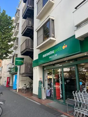 a store with a green sign on the side of a building at west16 in Tokyo