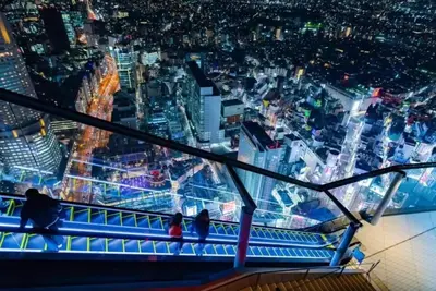 two people standing at the top of a viewing tower at night at FelizLife \u5357\u99ac\u8fbc 201 in Tokyo