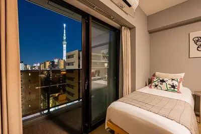 a bedroom with a large window with a view of a city at Mi-Hotel Asakusa Senso-ji in Tokyo