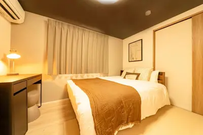 a hotel room with a bed and a desk and a bed sidx sidx sidx sidx at group and community house in Tokyo