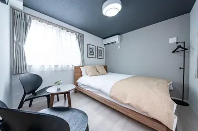a bedroom with a bed and a table and a chair at group and community house in Tokyo