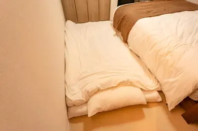 a bed with white sheets and pillows on it at group and community house in Tokyo
