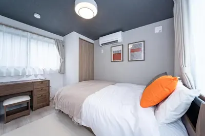 a bedroom with a bed and a desk and a window at group and community house in Tokyo