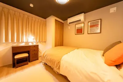 a bedroom with a bed and a dresser and a desk at group and community house in Tokyo