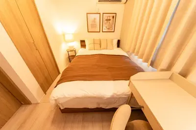 a small bedroom with a bed and a desk at group and community house in Tokyo