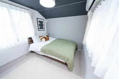 a small bedroom with a bed and a window at group and community house in Tokyo