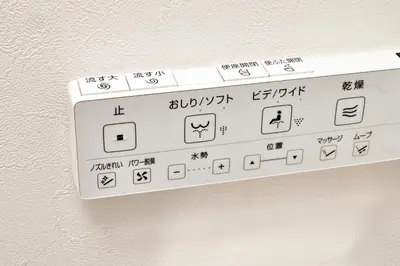 a white remote control on a wall with writing on it at Shibuya Hotel 502 in Tokyo