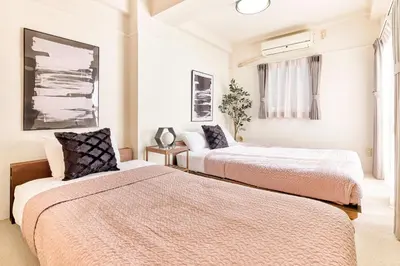 a bedroom with two beds and a window at Shibuya Hotel 502 in Tokyo