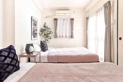 two beds in a bedroom with a window at Shibuya Hotel 502 in Tokyo