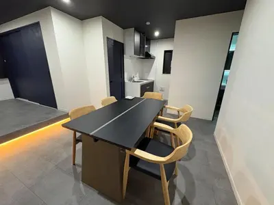 a dining room with a black table and chairs at COTO Premium Kyodo in Tokyo