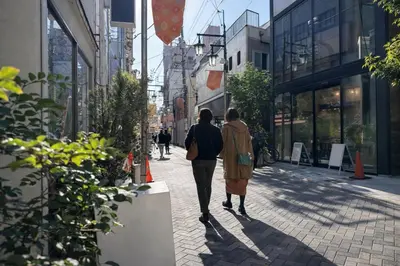 two people walking down a city street at louis stage \u897f\u30f6\u539f 103\u5ba4 in Tokyo