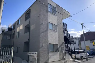 an apartment building on a street with a fence at louis stage \u897f\u30f6\u539f 103\u5ba4 in Tokyo