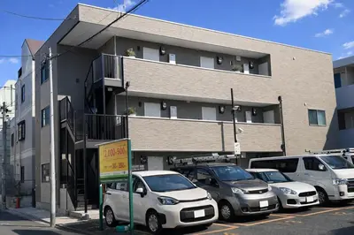 a parking lot with cars parked in front of a building at louis stage \u897f\u30f6\u539f 303\u5ba4 in Tokyo