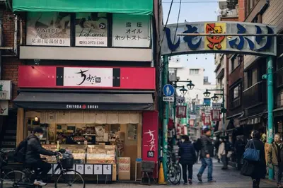 a group of people walking down a busy city street at louis stage \u897f\u30f6\u539f 303\u5ba4 in Tokyo