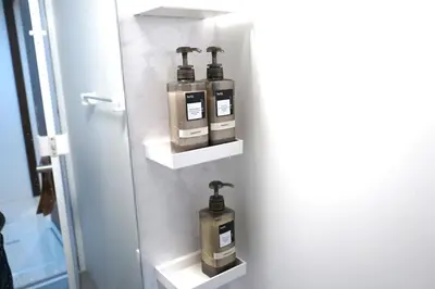 a bathroom with three soap dispensers on a wall at Private Hotel Skytree Garden in Tokyo