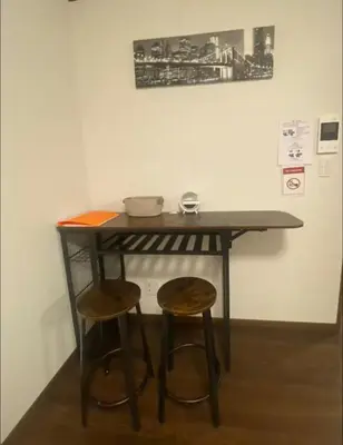a table and two stools in a room at Nexus Vill Morishita in Tokyo