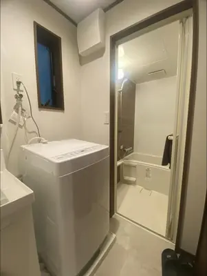 a white bathroom with a sink and a shower at Nexus Vill Morishita in Tokyo