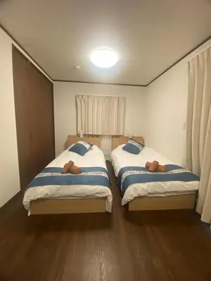 two beds sitting next to each other in a bedroom at Nexus Vill Morishita in Tokyo