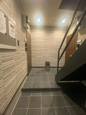 an empty hallway with a staircase in a building at Nexus Vill Morishita in Tokyo