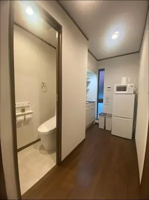 a bathroom with a toilet and a sink and a mirror at Nexus Vill Morishita in Tokyo