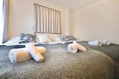 a bedroom with two beds with towels on the bed at \u30a8\u30de\u30fc\u30ec\u6771\u5c0f\u5ca9301 \u5c0f\u5ca9\u99c5\u5f92\u6b695\u5206 \u6700\u59275\u540d \u548c\u5ba4\u7573 in Tokyo