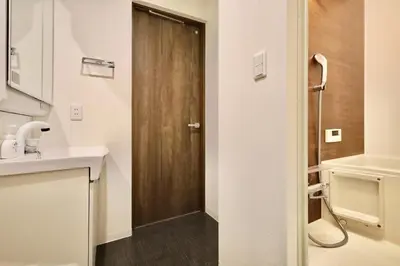 a bathroom with a sink and a wooden door at \u30a8\u30de\u30fc\u30ec\u6771\u5c0f\u5ca9301 \u5c0f\u5ca9\u99c5\u5f92\u6b695\u5206 \u6700\u59275\u540d \u548c\u5ba4\u7573 in Tokyo
