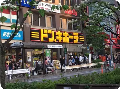 a group of people sitting outside of a building at \u677e\u30ce\u7af9101 in Tokyo