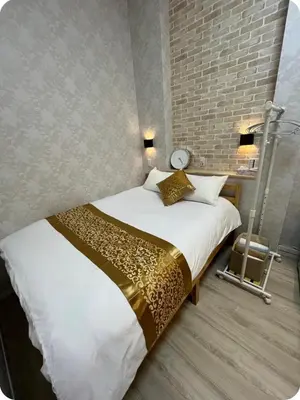 a bedroom with a large bed with a brick wall at \u677e\u4e43\u7af9102 in Tokyo