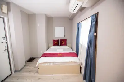 a small bedroom with a bed with red pillows at Asakusabashi MY Hostel max2 people-TT0495 in Tokyo