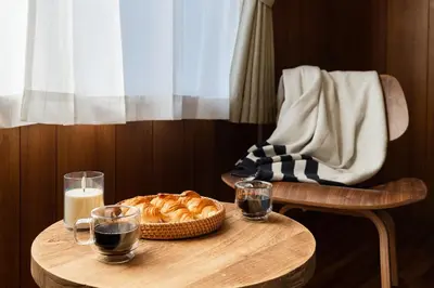 a table with a bowl of bread and glasses of milk at Hikihune Stay in Tokyo