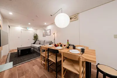a dining room and living room with a table and chairs at Hikihune Stay in Tokyo