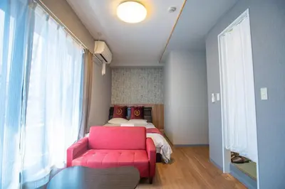 a bedroom with a pink chair and a bed at Asakusabashi MY Hostel-max3 people-TT0509 in Tokyo