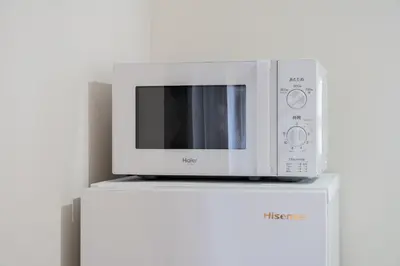 a microwave oven sitting on top of a white refrigerator at Higashimukoujima Stay in Tokyo