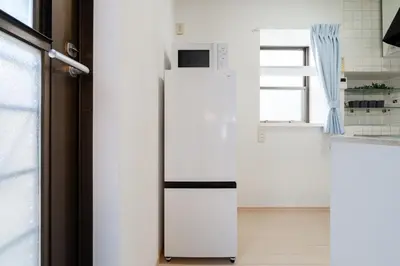 a white refrigerator in a kitchen next to a window at Higashimukoujima Stay in Tokyo