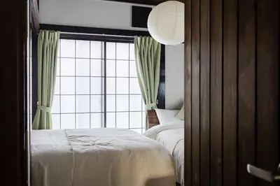 a bedroom with a bed and a large window at Higashimukoujima Stay in Tokyo