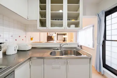 a kitchen with white cabinets and a sink at Higashimukoujima Stay in Tokyo