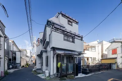 a white house with black trim on a street at Higashimukoujima Stay in Tokyo