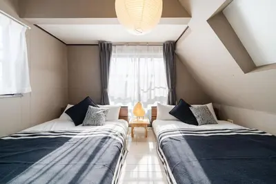 two beds in a small room with a window at Higashimukoujima Stay in Tokyo