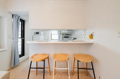 a kitchen with two wooden stools in front of a counter at Higashimukoujima Stay in Tokyo