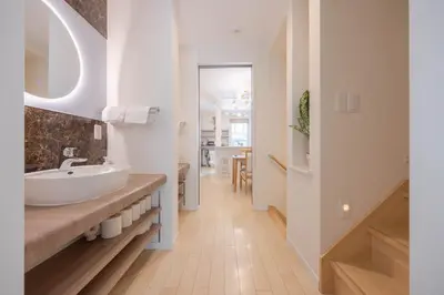 a white bathroom with a sink and a hallway at Shinjuku Private Family House in Tokyo