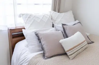 a pile of pillows sitting on top of a bed at Shinjuku Private Family House in Tokyo