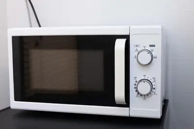 a white microwave oven sitting on top of a table at Shinjuku Private Family House in Tokyo
