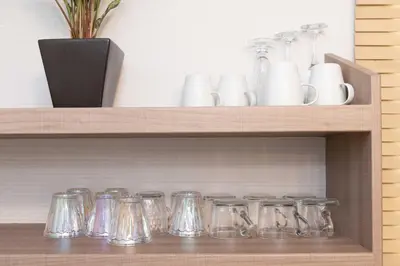 a wooden shelf with glass jars and vases on it at Shinjuku Private Family House in Tokyo