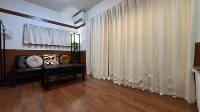 a living room with a couch and a window with curtains at Nakano OSHIYO House in Tokyo