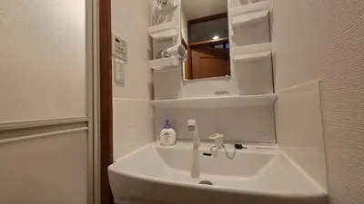 a white sink in a bathroom with a mirror at Nakano OSHIYO House in Tokyo