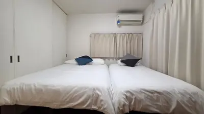 two beds sitting next to each other in a bedroom at Nakano OSHIYO House in Tokyo