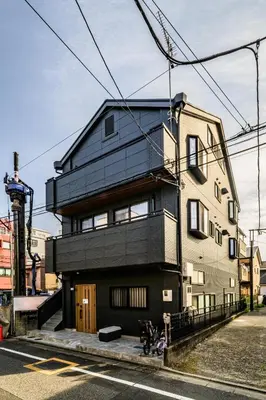 a black house on the side of a street at Chill Place 120 Ayase in Tokyo