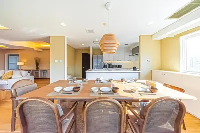 a dining room with a large wooden table and chairs at Penthouse Ueno in Tokyo